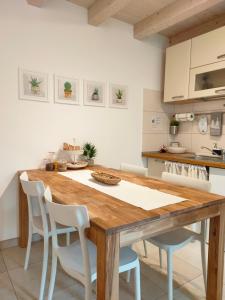 a kitchen with a wooden table and white chairs at Casa Vacanze Barcola in Trieste