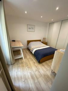 a small bedroom with a bed and a table at Le Coeur du Port de Golfe Juan - Parking - Clim - Wifi in Vallauris
