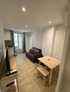a living room with a couch and a table at Le Coeur du Port de Golfe Juan - Parking - Clim - Wifi in Vallauris