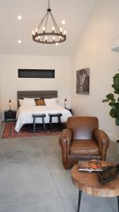 a bedroom with a bed and a couch and a chair at Hidden Hacienda in Temecula