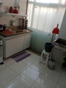 a kitchen with a sink and a stool in it at Guest House Paraiso Pataxos in Porto Seguro