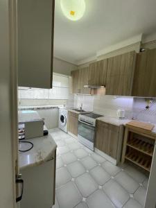 エストリルにあるEstoril Top Beach Apartmentの白いタイルフロアの広いキッチン(木製キャビネット付) +7枚の写真