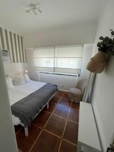 エストリルにあるEstoril Top Beach Apartmentのベッドと窓のある小さな寝室