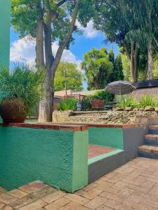 a park with a bench with plants and trees at Timebridge Mansions in Johannesburg