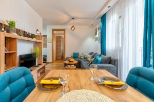 una sala de estar con una mesa y un sofá en Apartman LVS Zlatibor, en Zlatibor