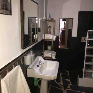 y baño con lavabo blanco y espejo. en Casa Rural La Casa de Lolo en Minas del Castillo de las Guardas