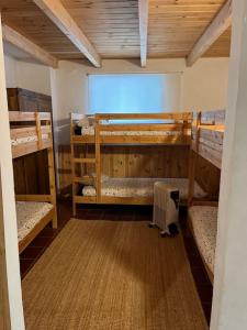 a room with three bunk beds in a house at Casa Rural La Casa de Lolo in Minas del Castillo de las Guardas
