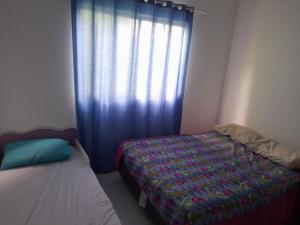 Schlafzimmer mit einem Bett und einem Fenster in der Unterkunft Cantinho da Bethânia in São Pedro da Aldeia