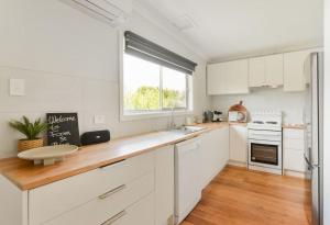 a kitchen with white cabinets and a large window at Foam St Bliss in Rosebud