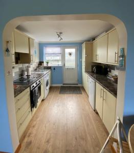a kitchen with white appliances and an archway at Dunes View - Atlantic Bay in Perranporth