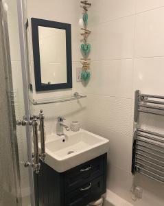 a bathroom with a sink and a mirror at Dunes View - Atlantic Bay in Perranporth +57 photos