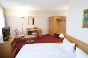 a hotel room with a bed and a table and chairs at TRIP INN Axxon Hotel in Brandenburg an der Havel