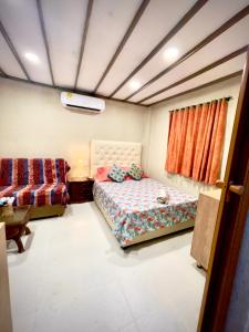 a bedroom with a bed and a couch and a table at Casona La Española in Cartagena de Indias