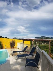 a patio with chairs and a swimming pool on a deck at Casa Star - Vista para as Montanhas in Monte Sião