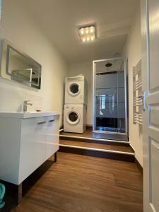 a bathroom with a sink and a washing machine at Captain YOO - Ginkgo Biloba - Cocon moderne sur le port in Fécamp
