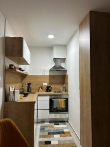 a kitchen with white cabinets and a stove top oven at Sova studio apartment Bjelasnica in Bjelašnica
