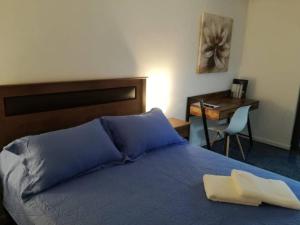 a bedroom with a bed with blue sheets and a desk at Estado Apart 103 Full equipado hermoso in Santiago