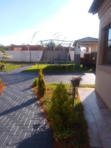 a brick walkway in a yard next to a house at TLZ Prop B&B in Pretoria