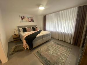 een slaapkamer met een bed, een raam en een tapijt bij Ferienwohnungen Univers A&B in Bad Harzburg