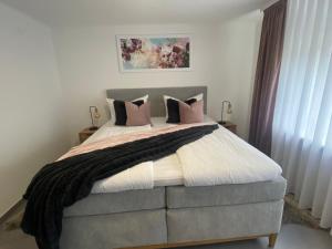 een slaapkamer met een groot bed met roze kussens bij Ferienwohnungen Univers A&B in Bad Harzburg