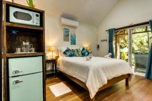1 dormitorio con 1 cama y TV en la parte superior en Azure Del Mar en Maya Beach