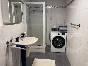 een badkamer met een wasmachine en een wastafel bij Ferienwohnungen Univers A&B in Bad Harzburg