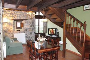 a living room with a wooden table and a staircase at Rodiles Rural Apartamentos in Selorio