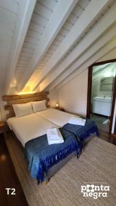 a bedroom with a large bed and a rug at Casa das Lajes in Caldeira
