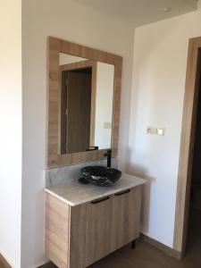 La salle de bains est pourvue d'un lavabo et d'un miroir. dans l'établissement Apartement haut standing avec piscine à la Marina Saidia, à Saïdia