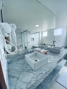 baño con 2 lavabos y espejo grande en Hotel Real, en Cabo Frío