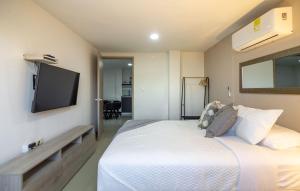 a bedroom with a bed and a tv on the wall at Bahari Cartagena Suites in Cartagena de Indias