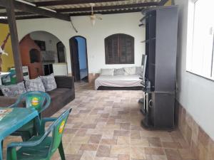 a living room with a couch and a refrigerator at Cantinho da Bethânia in São Pedro da Aldeia