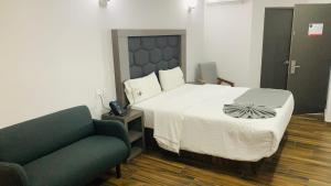 - une chambre avec un lit et un canapé dans l'établissement Hotel Bugari Aeropuerto Guadalajara, à Guadalajara