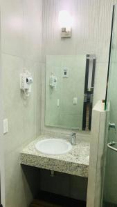 La salle de bains est pourvue d'un lavabo et d'un miroir. dans l'établissement Hotel Bugari Aeropuerto Guadalajara, à Guadalajara