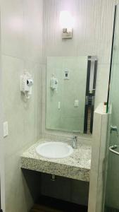 ein Bad mit einem Waschbecken und einem Spiegel in der Unterkunft Hotel Bugari Aeropuerto Guadalajara in Guadalajara