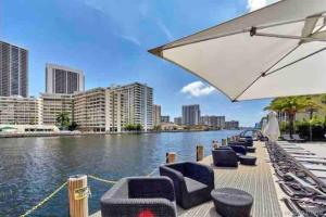 a row of chairs and an umbrella next to a river at Modern apartment A - Beach Walk Resort in Hallandale Beach