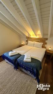 una camera da letto con un grande letto con due asciugamani di Casa das Lajes a Caldeira
