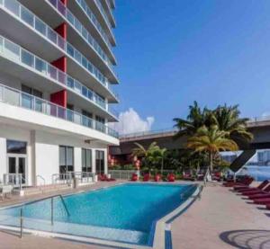a swimming pool in front of a building at Modern apartment A - Beach Walk Resort in Hallandale Beach