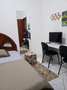 Schlafzimmer mit einem Bett und einem Schreibtisch mit einem Computer in der Unterkunft Casa Star in Monte Sião