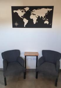 Deux chaises et une table avec une carte sur le mur dans l'établissement Alojamiento Trayken, à San Martín de los Andes
