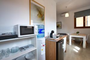 a small kitchen with a microwave and a table at Cuencaloft Matadero viejo in Cuenca