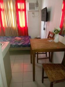 Camera piccola con letto, tavolo e scrivania. di Urban Deca Tower @ Graceysplace Unit 4 Mandaluyong a Manila