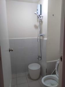 La petite salle de bains est pourvue d'une douche et de toilettes. dans l'établissement Urban Deca Tower @ Graceysplace Unit 4 Mandaluyong, à Manille