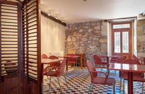 ein Restaurant mit Tischen und Stühlen und einer Steinmauer in der Unterkunft Hotel Konbenio in Amorebieta-Etxano