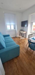 S Soares Beato 6 3D في لشبونة: غرفة معيشة مع أريكة زرقاء وطاولة
