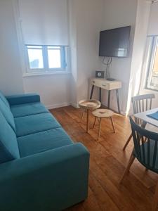 S Soares Beato 6 3D في لشبونة: غرفة معيشة مع أريكة زرقاء وطاولة