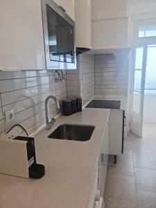 a kitchen with a sink and a tv on the wall at S Soares Beato 6 3D in Lisbon