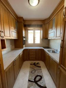 a kitchen with wooden cabinets and a sink and a window at Apartment Kolar in Bar +4 photos