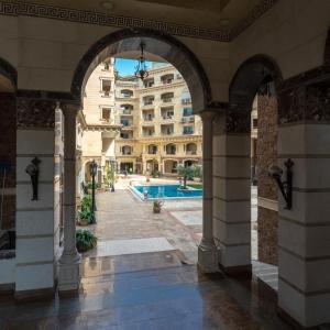 Elite Pyramids Boutique Hotel في القاهرة: ممر في مبنى به مسبح