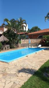 a swimming pool in a yard with a house at Palace Hotel Jacarezinho in Jacarèzinho